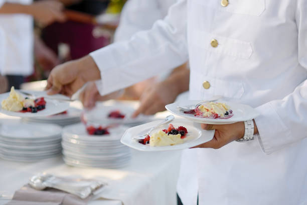 Waiter carrying three plates with dessert