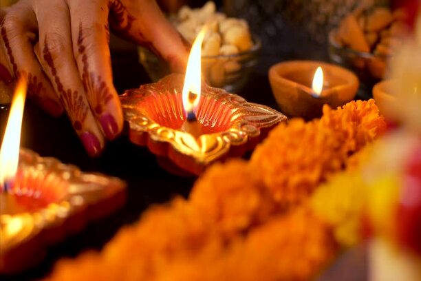 hands of a girl decorating the oil lamp on the table